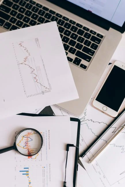 Graphique d’étude de marché et calculatrice à titre illustratif sur un bureau en bois pour l’analyse commerciale.
